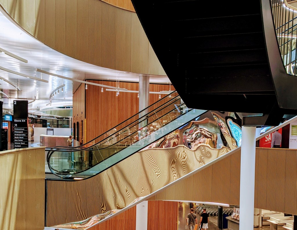 Escalators in a mall, where the reflection in the side panel is very distorted and yields interesting curves.