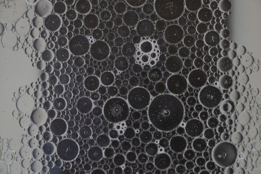 Soapy bubbles over a black stripe on a white background. 