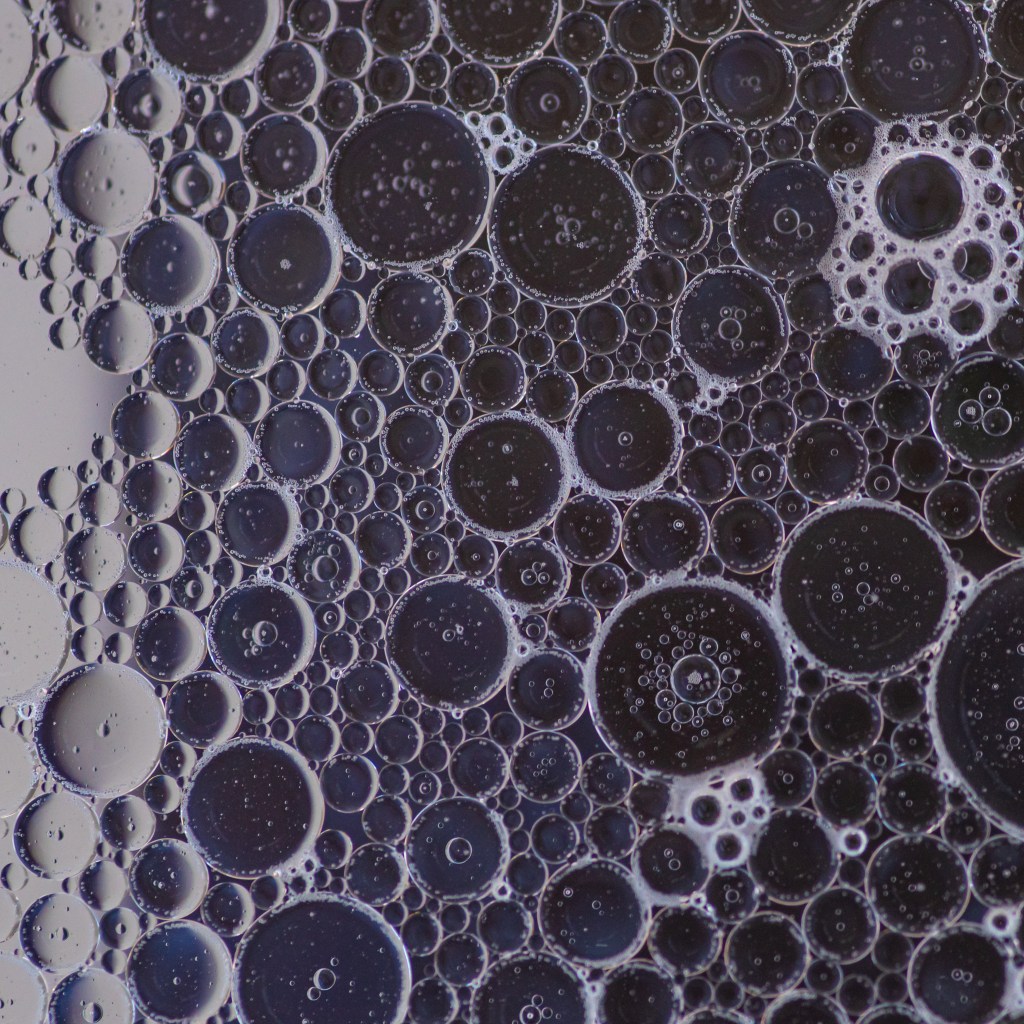 Soapy bubbles over an indigo background. The effect is one of moon craters.