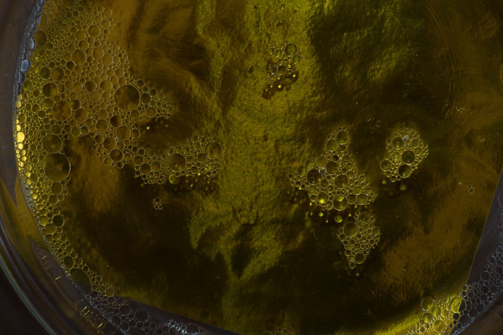 Bowl of water with bubbles on top of a yellow foil. The picture is underexposed.
