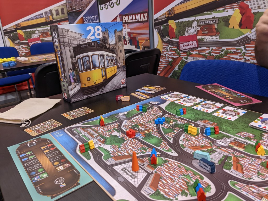 28 - a board with a map of Lisbon, trams and meeples waiting at stops.