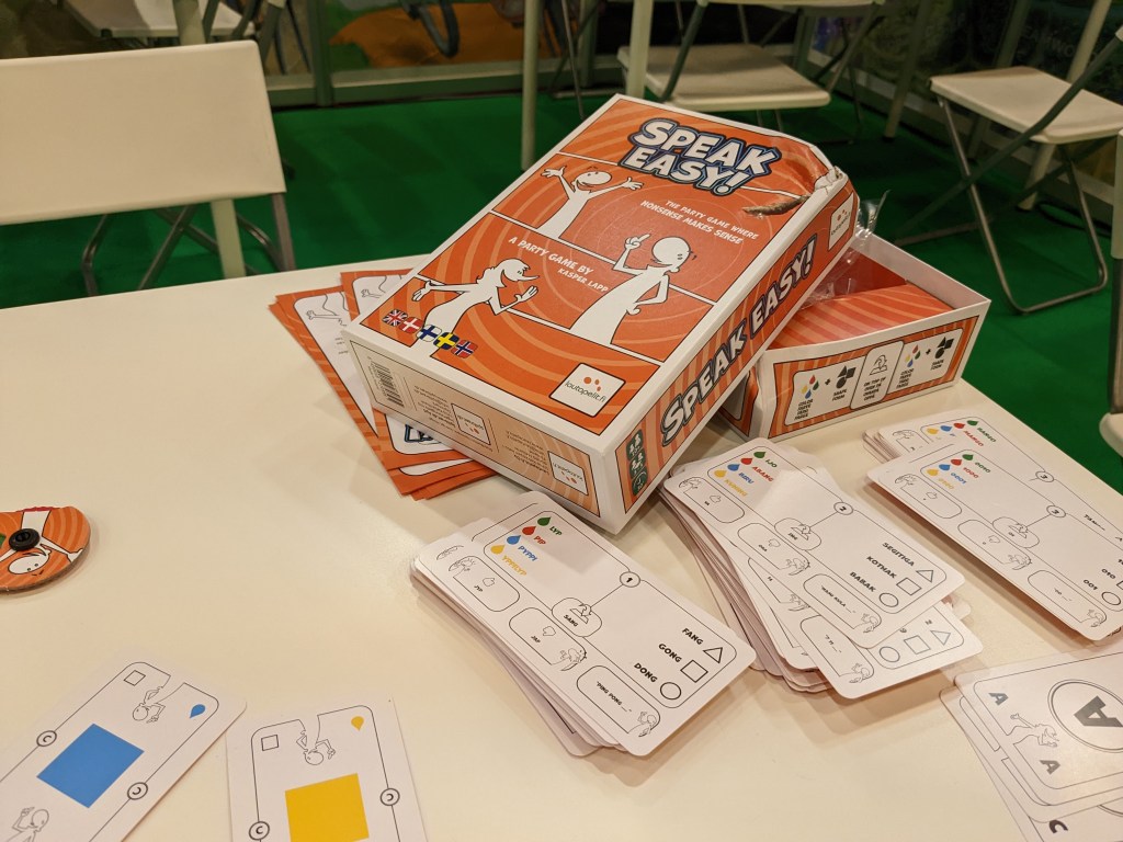 A box of Speak Easy and a few example cards for the fabricated languages.