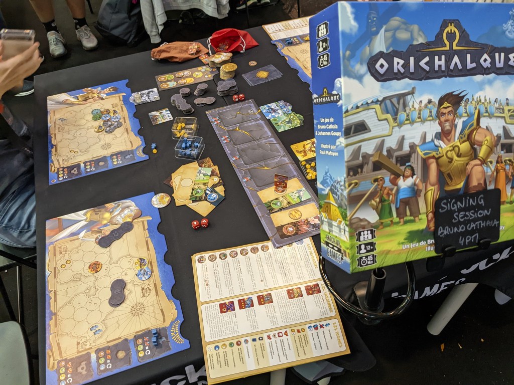 Orichalcum - player mats showing round tile places; the back player mat still has some tiles placed on it.