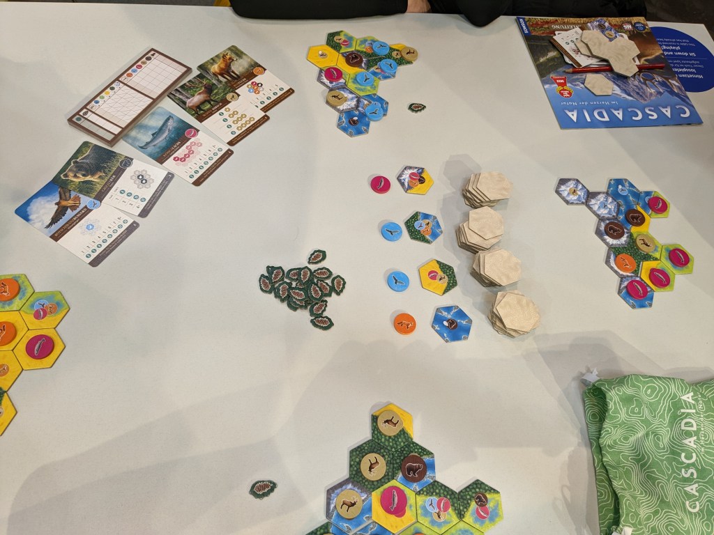 Cascadia: scoring cards with different animal patterns, ecosystem colored tiles and animal tokens.