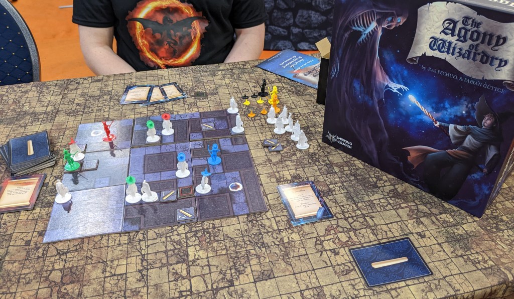 Agony of Wizardry - a maze board with colored figures and white figures with colored hats.