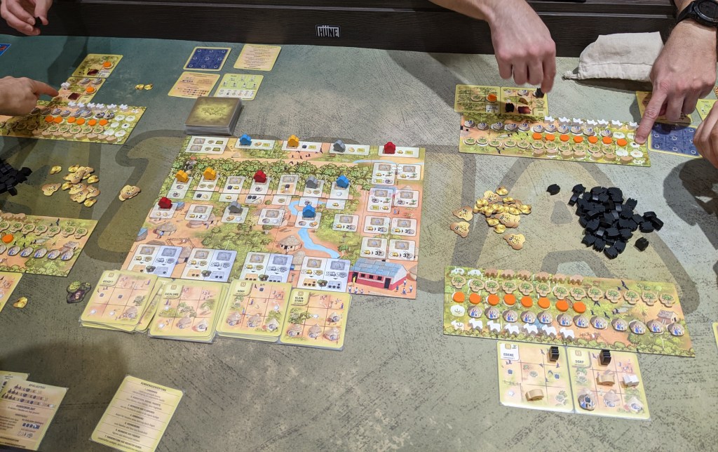 Atiwa: an action board with meeples on it, and resource boards with trees, fruits and bats.