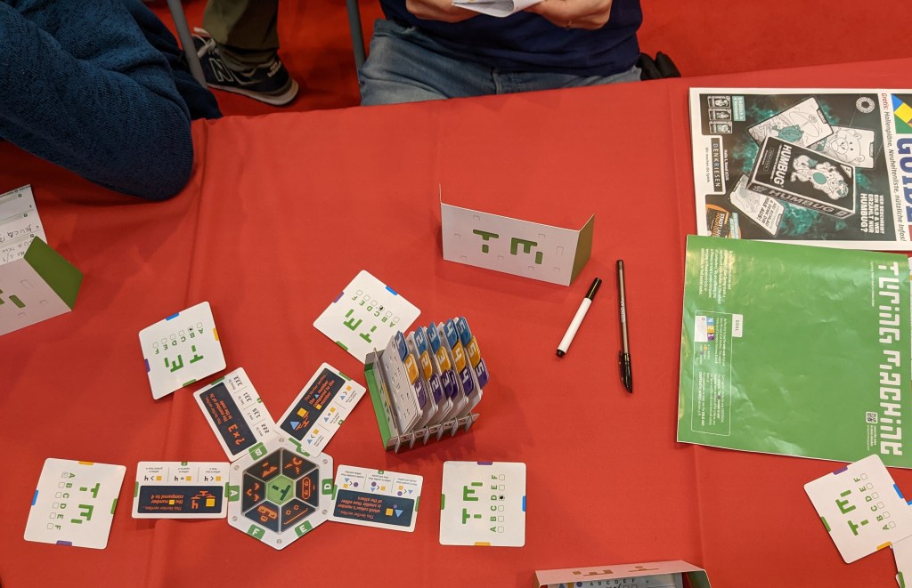 Turing machine - a set of numbered punch cards and instruction cards displaying various instructions such as "yellow square is less than 4".