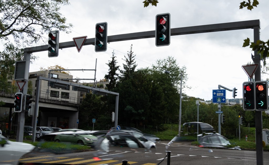 Composite image showing traffic and traffic lights on a intersection with both the red and green lamps on.