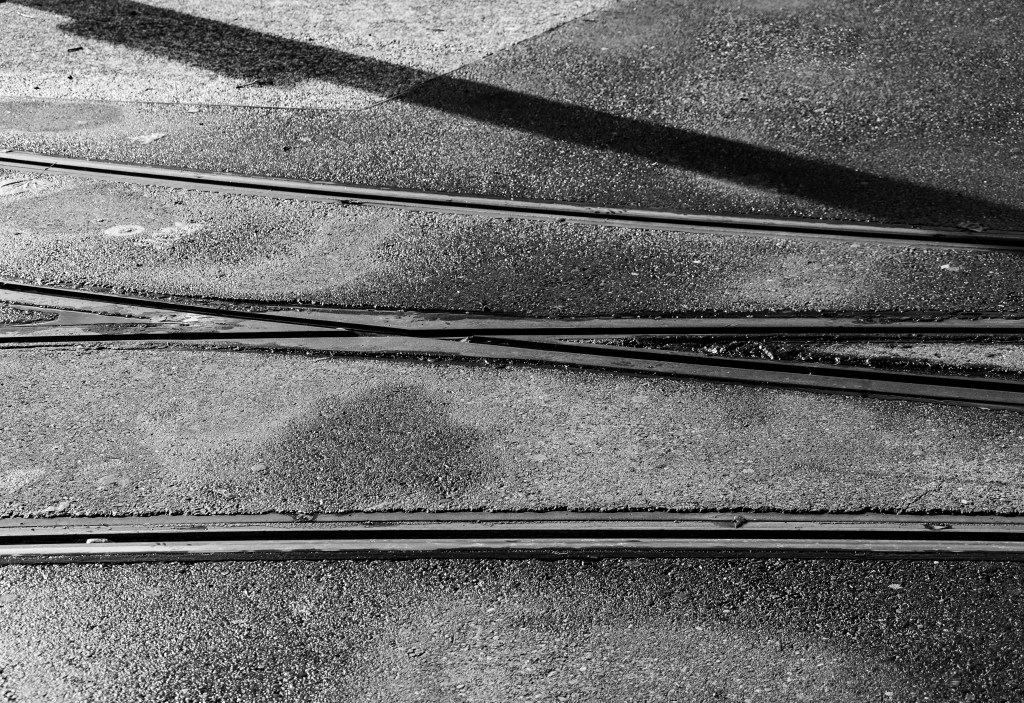 Close-up of a tram tracks intersection, processed in high contrast black&white.