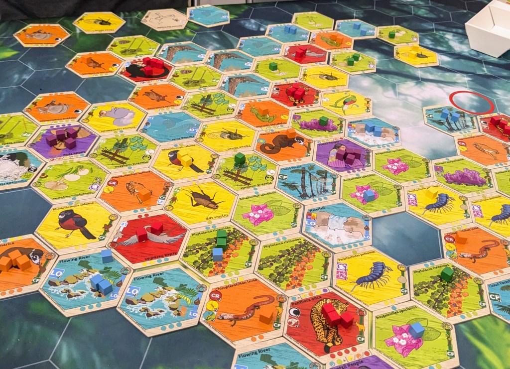 kCaloria: colorful hexagonal tiles with pictures of animals and plants with colored cubes on some of them