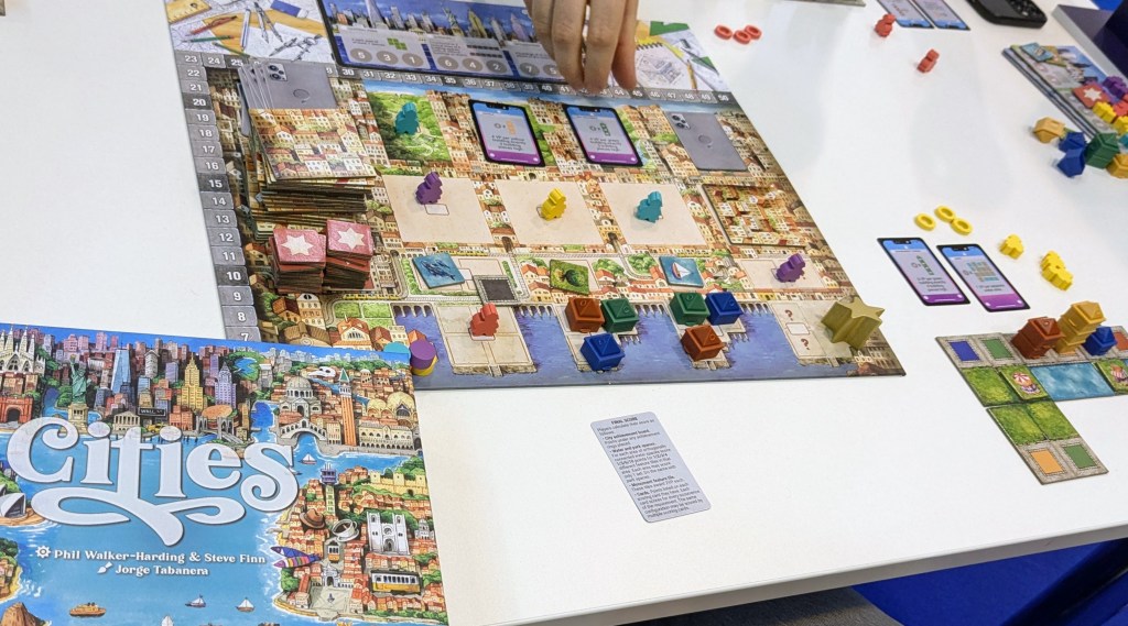 Cities: central board with meeples, bonus cards and building blocks; personal board with city tiles and skyscrapers made of the building blocks
