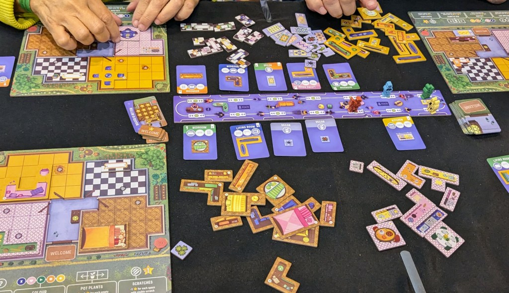 Happy Home: player board depicting a house plan, colored tiles of furniture, central board to choose furniture