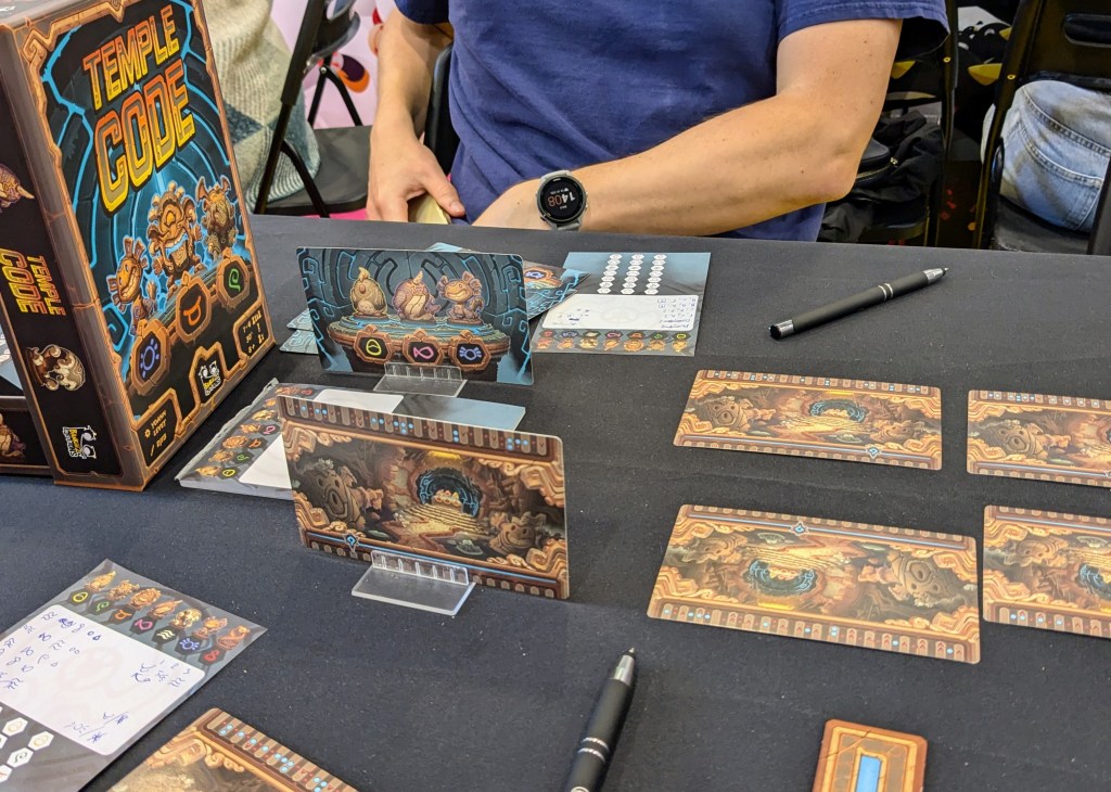 Temple Code: cards with colorful symbols, pens and papers depicting the working of a solution