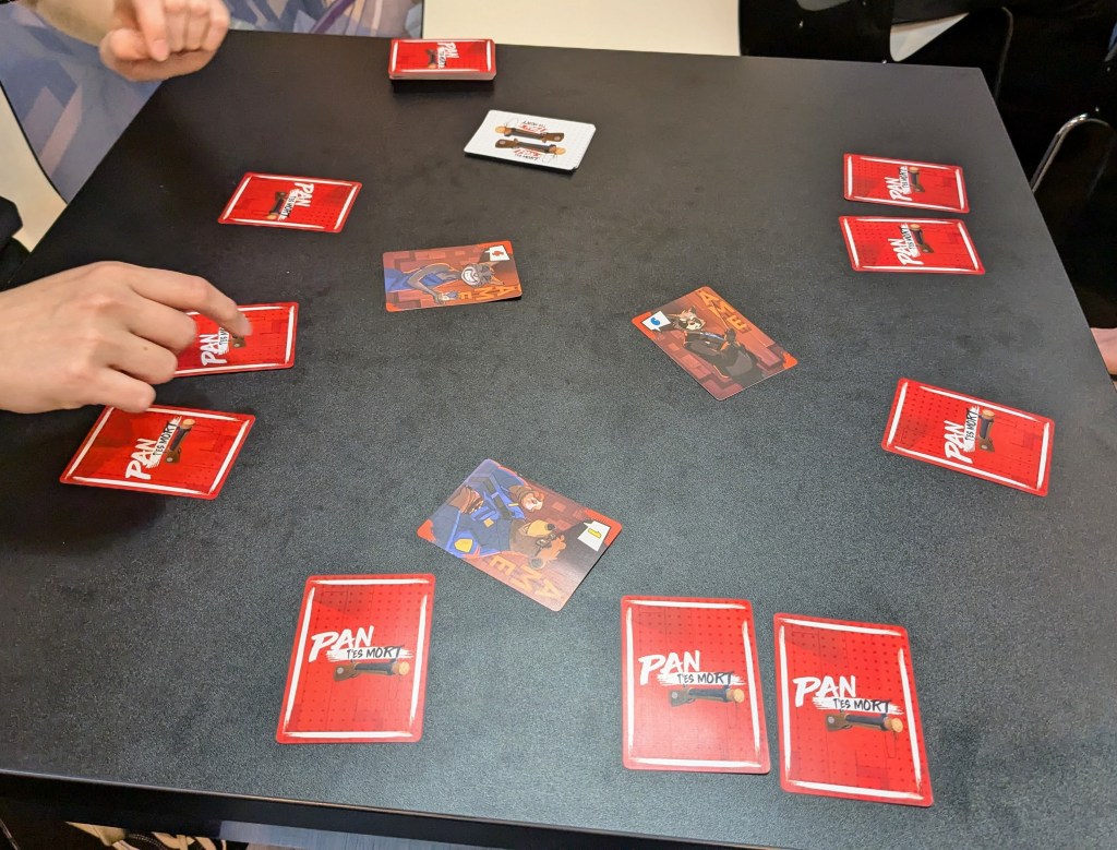 Pan T'es Mort : cards with cartoon characters and numbers; some of them flipped with their red back visible