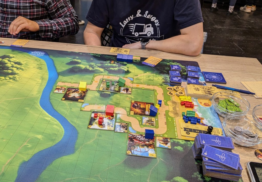 Theme Park Mania: path tiles with theme park rides tiles on the side of the path; small wooden booths and meeples