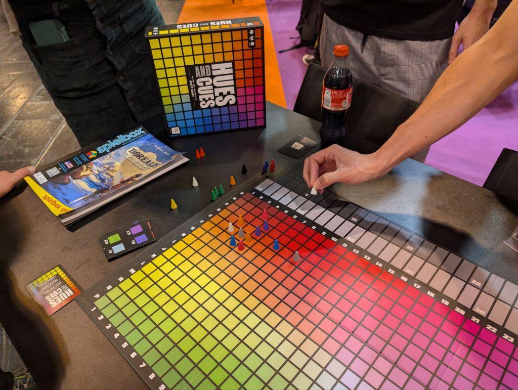 A board containing a large amount of colors going from brown to green vertically and from brown to purple horizontally (and then some), with a bunch of conic tokens all in the same area around red/orange hues.
