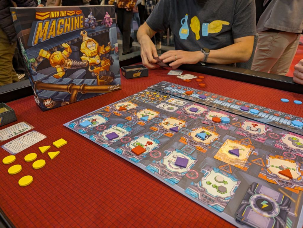 A colorful board with various symbols, a track on top, and multiple colored tokens on the different symbols of the board.